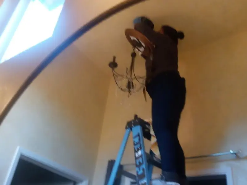 Electrician installing a chandelier in a East Bakersfield residence